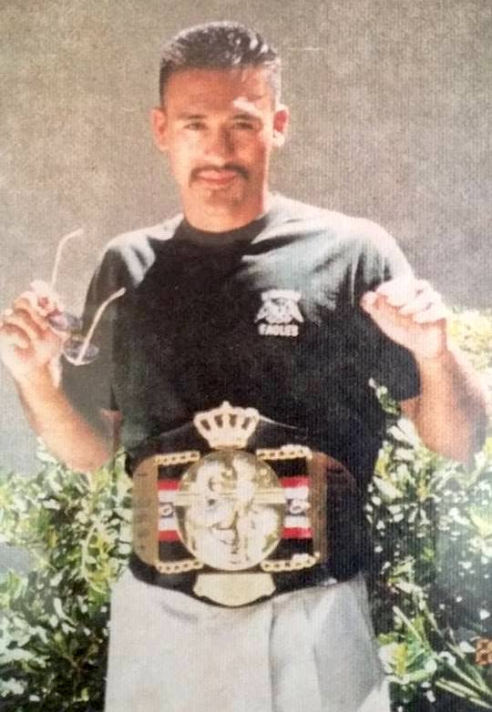 A young Guadalupe posing with a boxing championship belt around his waist.