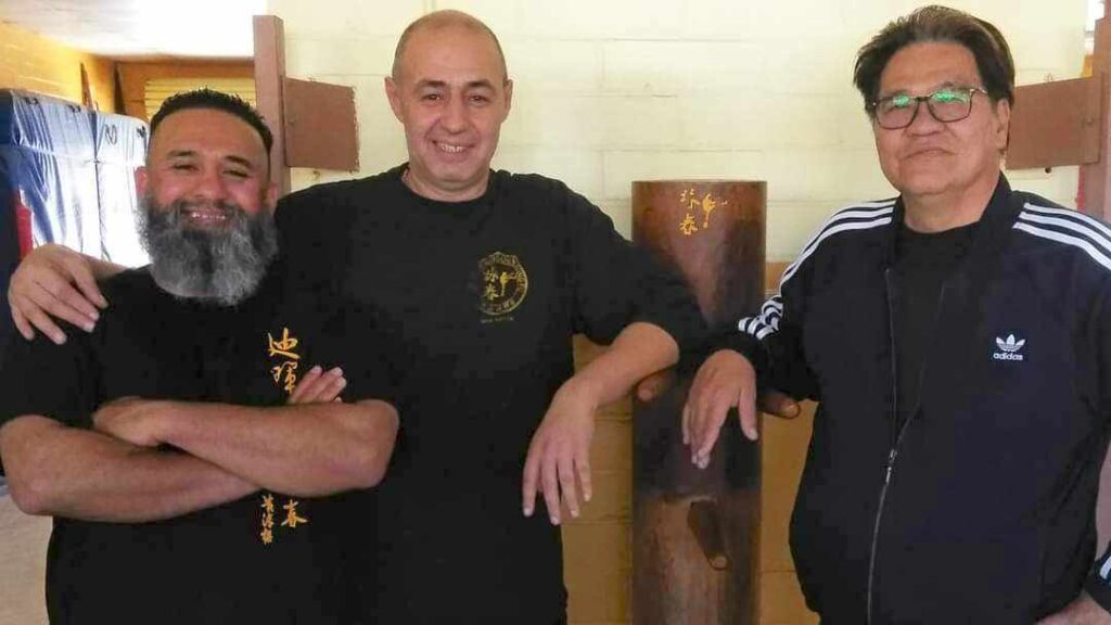 Guadalupe, with his arms crossed with two other instructors in the training facility